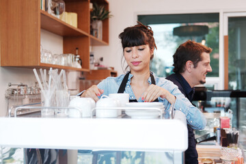 Smiling Caucasian Young barista couple love is wearing apron and working in the coffee shop. Start up for small cafe business concept.