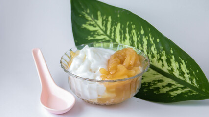 Sweet Rice Noodles with Coconut Cream in a glass cup on a white table.