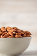 Almonds in ceramic bowl on white wood table.organic Diet raw material