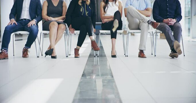 Switching it up. 4k video footage of a group of unrecognizable businesspeople seated next to each other while waiting for interviews in the office.