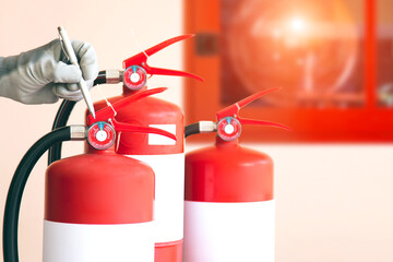 Obraz premium Close up fire extinguisher and firefighter checking pressure gauge level for protection and prevent and safety rescue and use of equipment on fire training concept.