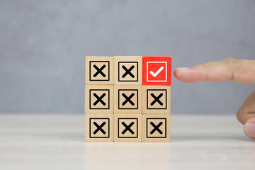 Hand choose wooden block stack with check mark and cross symbol for customer survey service and...