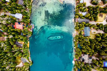 Aerial view of a shipwreck in blue waters. 