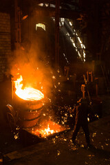 Metallurgist removing slack from hot molten metal