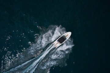 Boat trip at sea. White boat with a black awning movement on the water drone view. Speedboat on...
