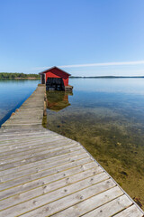Wooden jetty, boathouse and ocean in Åland Islands, Finland, on a sunny day in the summer.