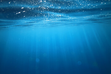 ocean underwater rays of light background, under blue water sunlight