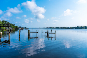 Pink sunrise with reflection in the river over the Sebastian River over a wooden pier in Little Hollywood, Mikko, Florida. Typical view of the beautiful nature in Florida