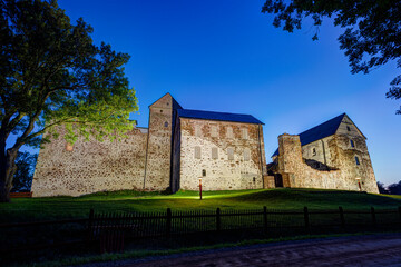 Fototapeta premium Lit medieval Kastelholm Castle in Åland Islands, Finland, at dusk in the summer.