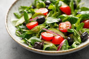 Salad with corn salad, cucumber, olives and tomato