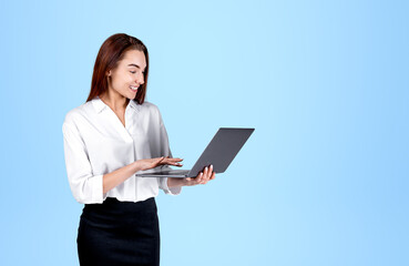 Young office woman typing on laptop, mockup blue background