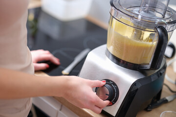 Woman adjusting speed of food processor closeup