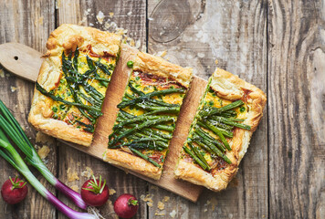 Vegetarian quiche pie with asparagus. Fresh homemade asparagus quiche pie served on rustic wooden table. - obrazy, fototapety, plakaty