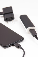 External powerbank or electric charger charging empty battery of smartphone or mobile phone