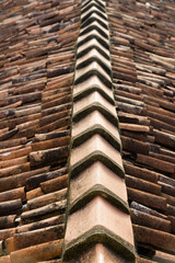 Closeup of roof ridge and broken clay roof tiles
