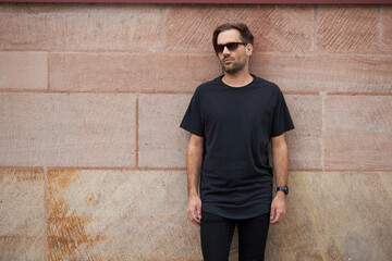 Black blank t-shirt on a hipster handsome male model with space for your logo or design in casual urban style