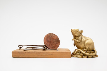 figurine of a mouse near a mousetrap with bitcoin on a white background