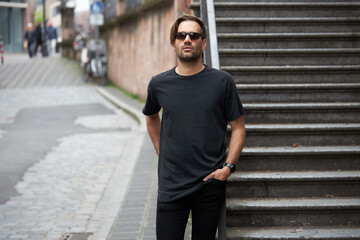 Black blank t-shirt on a hipster handsome male model with space for your logo or design in casual urban style