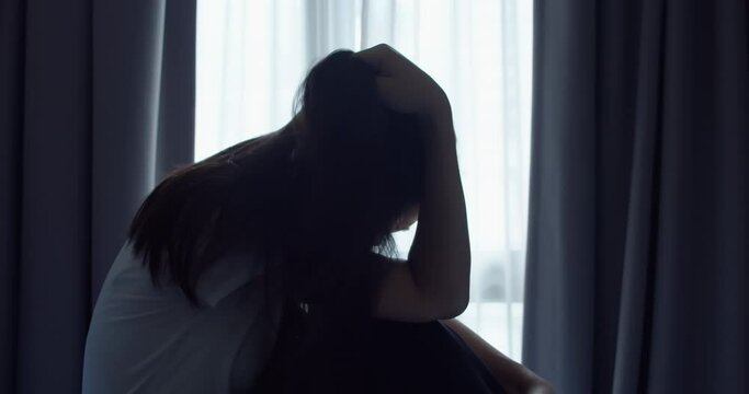 Silhouette of Asian women are alone and under stress in the bedroom.Quarantine during the epidemic (Covic 19). Young woman with depression and have problems in life.Lifestyle concept.