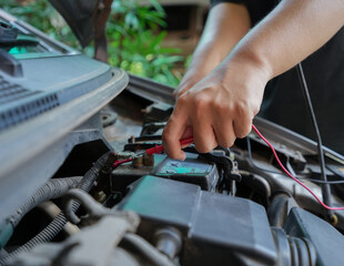 Close up and Selective focus of technician is checking the car battery for availability.
