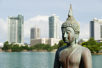 Fototapeta na wymiar Gangaramaya temple Buddha statues with the city of Colombo in background