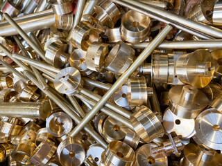 Brass scrap waste from manufacturing process, landscape view.