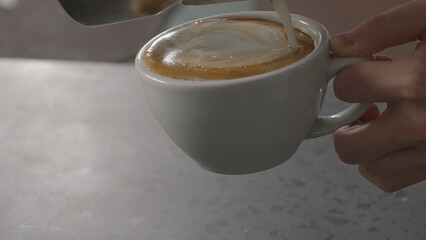 man pour steamed milk, making cappuccino