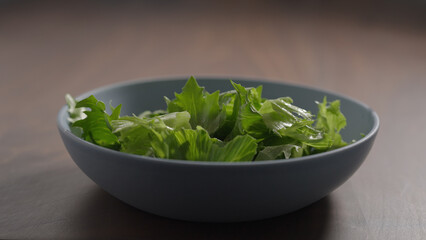 making salad, frisee lettuce in blue bowl on wood table