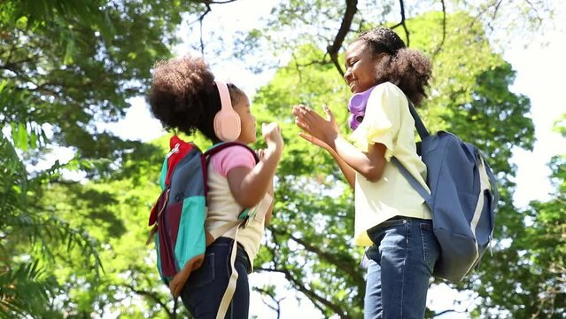 Couple African American girls dancing and relax in the public park after hard learning in school. Outdoor education concept 