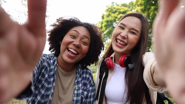 Multiracial students friends making selfie and showing bright smile, posing outdoors in campus at the park. Teens happy about entering university