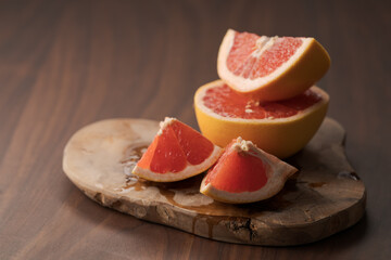 Fototapeta na wymiar Sliced grapefruit on wood board closeup