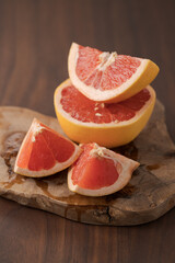 Obraz na płótnie Canvas Sliced grapefruit on wood board closeup