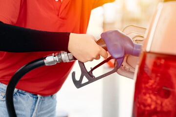 closeup stuff handle gasoline fuel nozzle to refuel. Vehicle fueling at oil gas station with high...