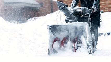 a janitor on a snowplow removes snow in the courtyard of a residential building