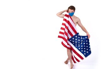 Sexy man wrapped in an American flag. Brutal topless guy on a white background. Isolate. USA Freedom Day.