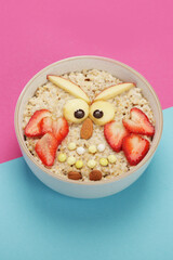 Creative oatmeal breakfast for kids on colourfull background.