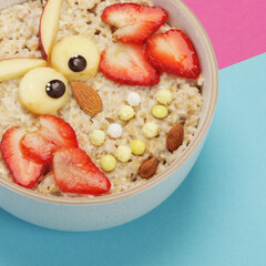 Creative oatmeal breakfast for kids on colourfull background.
