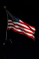 Closeup of american USA flag, stars and stripes, united states of america. On a black background. At night. All seasons.