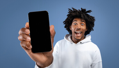 Amazed funky black guy showing cell phone with empty screen