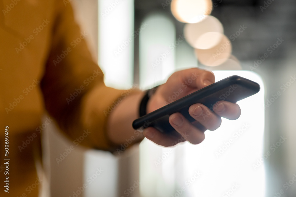 Aufkleber unrecognizable man using cellphone texting standing in doorway in office