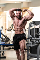 Fototapeta na wymiar Biceps Pose Of A Young Man In Gym