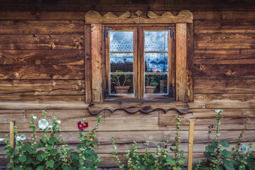 Fototapeta na wymiar Window of wooden traditional cottage in Warmia and Mazury region, Poland