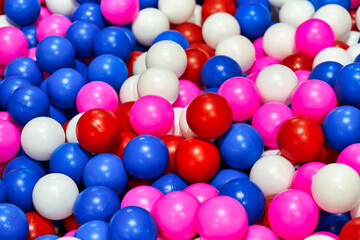 Background texture of multi-colored plastic balls on playground. Dry pool filler.