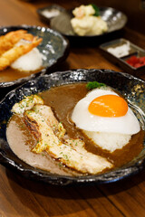 Japanese curry rice with fried egg and grilled pork belly.