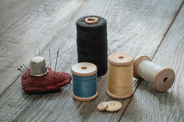 sewing supplies and accessories on a wooden background, retro style, needlework and clothing repair