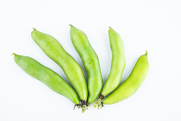 Fresh broad bean pods on white background