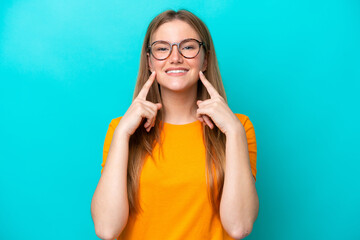 Young caucasian woman isolated on blue background smiling with a happy and pleasant expression