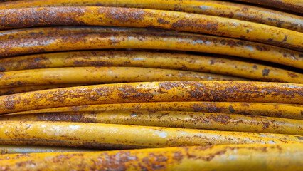 Close-up of rust wire coils in metal steel industrial yard or storage area, steel wire coils or wire rod for wires industry production, concrete usage and building construction 