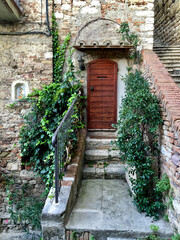 Viale Indipendenza Street view of Perugia, Umbria, Italy. Medieval stone house with ivy. Italian house. Fragment of facade. Wooden door. Stone wall, medieval building. Photo made in Umbria. 