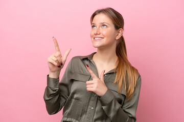 Young caucasian woman isolated on pink background pointing with the index finger a great idea